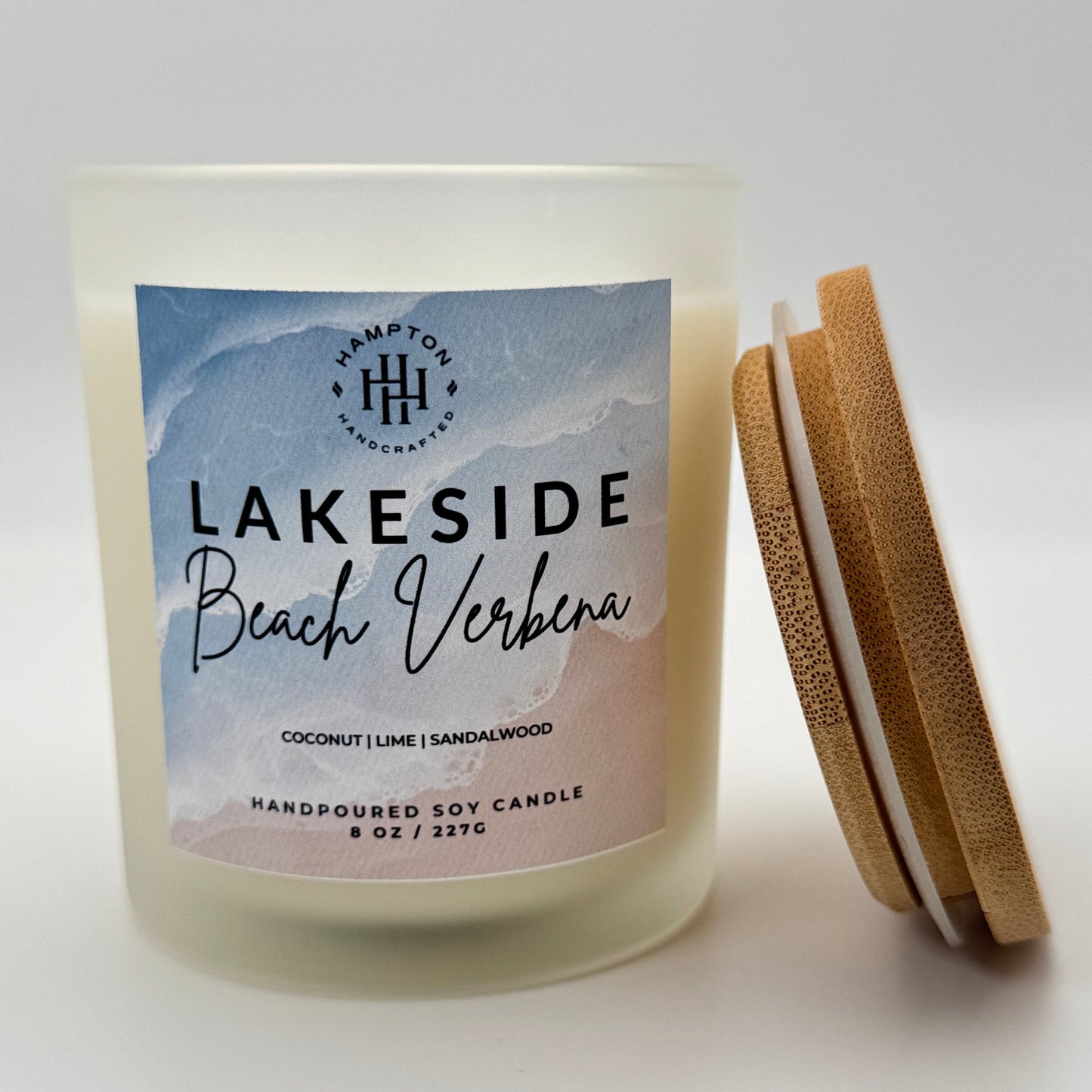 Candle labeled 'Lakeside Beach Verbena' with bamboo lid leaning against the side